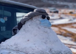 مرتديًا كمامة .. بالصور: مواطن يظهر ابداعاته ويبني رجل الثلج في علقان